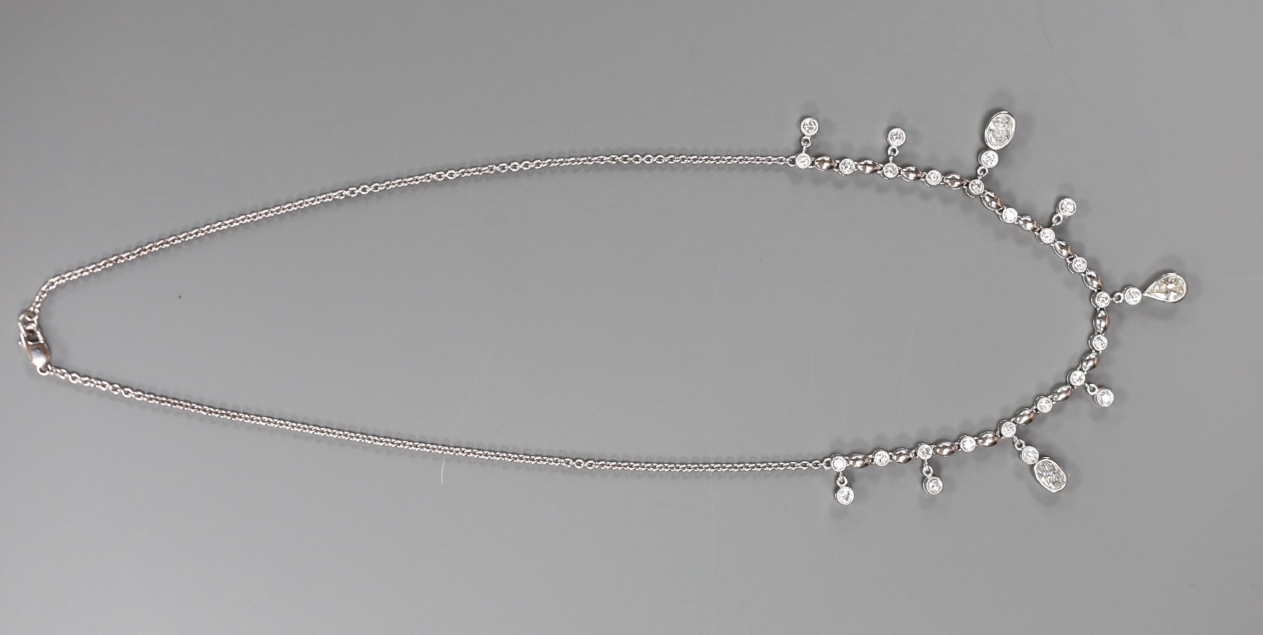 A modern 750 white metal and diamond cluster set drop fringe necklace, 42cm, gross weight 11.8 grams